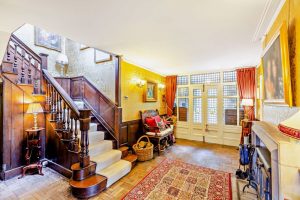hallway with period wooden staircase and panelled walls in house for sale with Rickitt Partnership estate agency