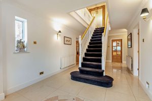 the hallway with central staircase at a detached house for sale in Bettisfield