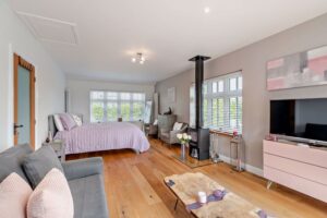 bedroom with a log burner in a house for sale near Holt