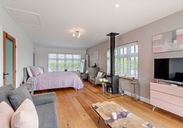 bedroom with a log burner in a house for sale near Holt